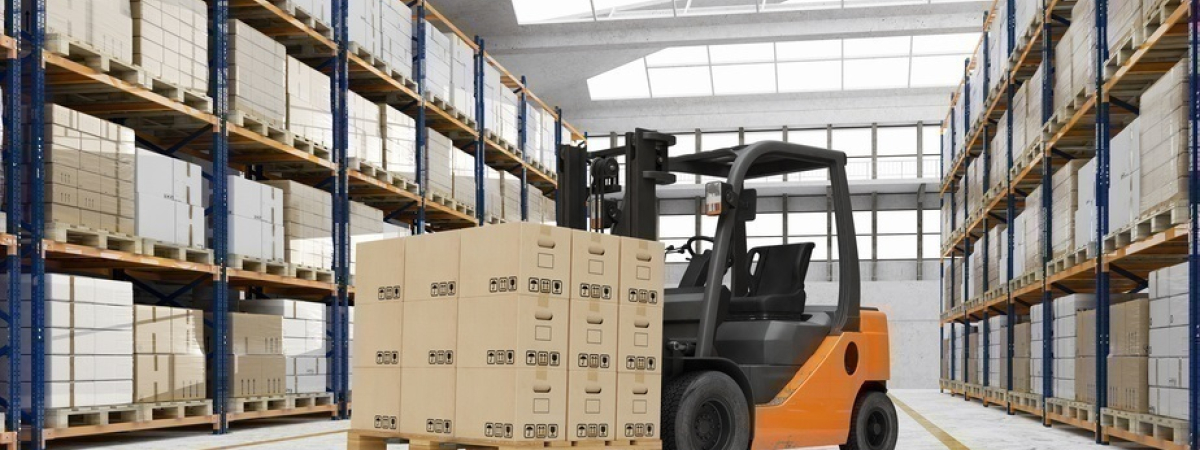Gabelstapler in Lagerhalle mit vielen Kartons auf einer Palette