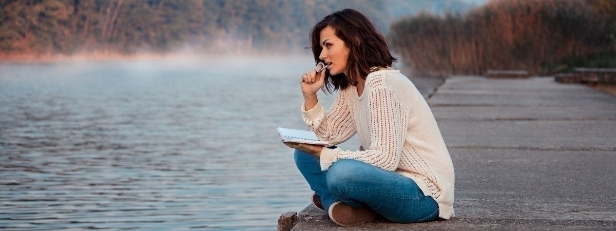 Frau mit Schreibblock am See