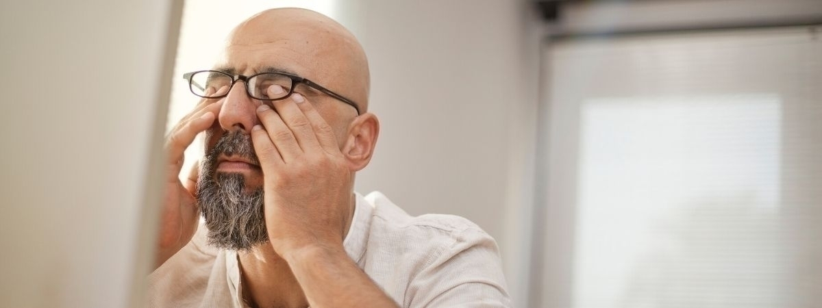 Mann, der sich die Augen reibt